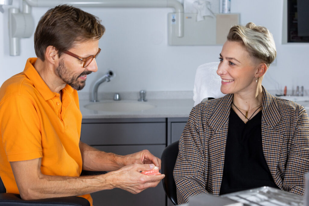 Zahnarzt bespricht mit einer Patientin die Gestaltung ihrer Frontzähne