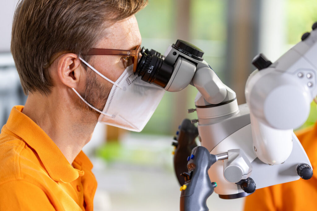 Dr. Ulrich Schmitt behandelt unter dem Dentalmikroskop